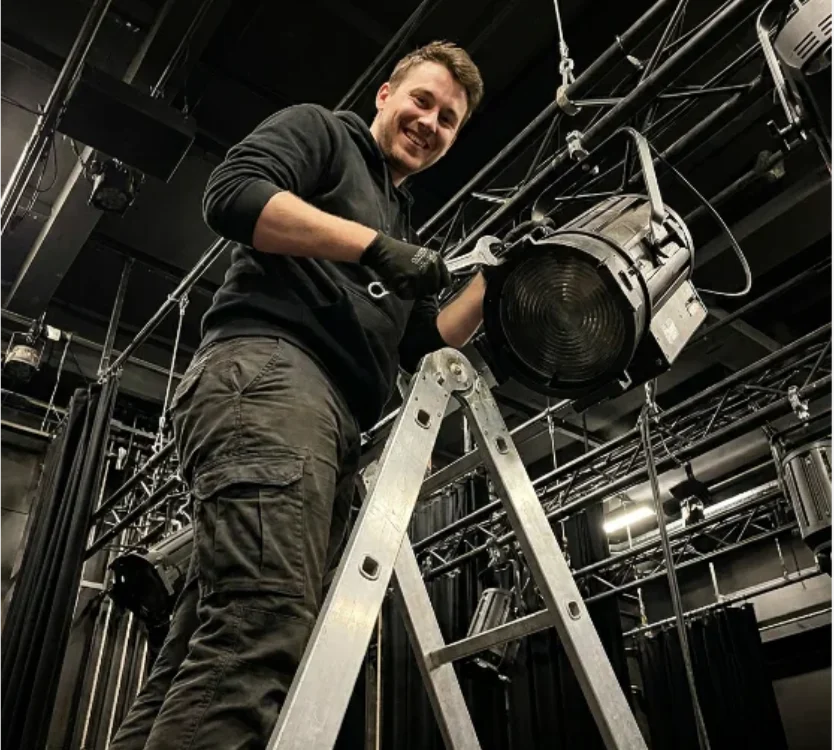 Crew rigging truss above a stage